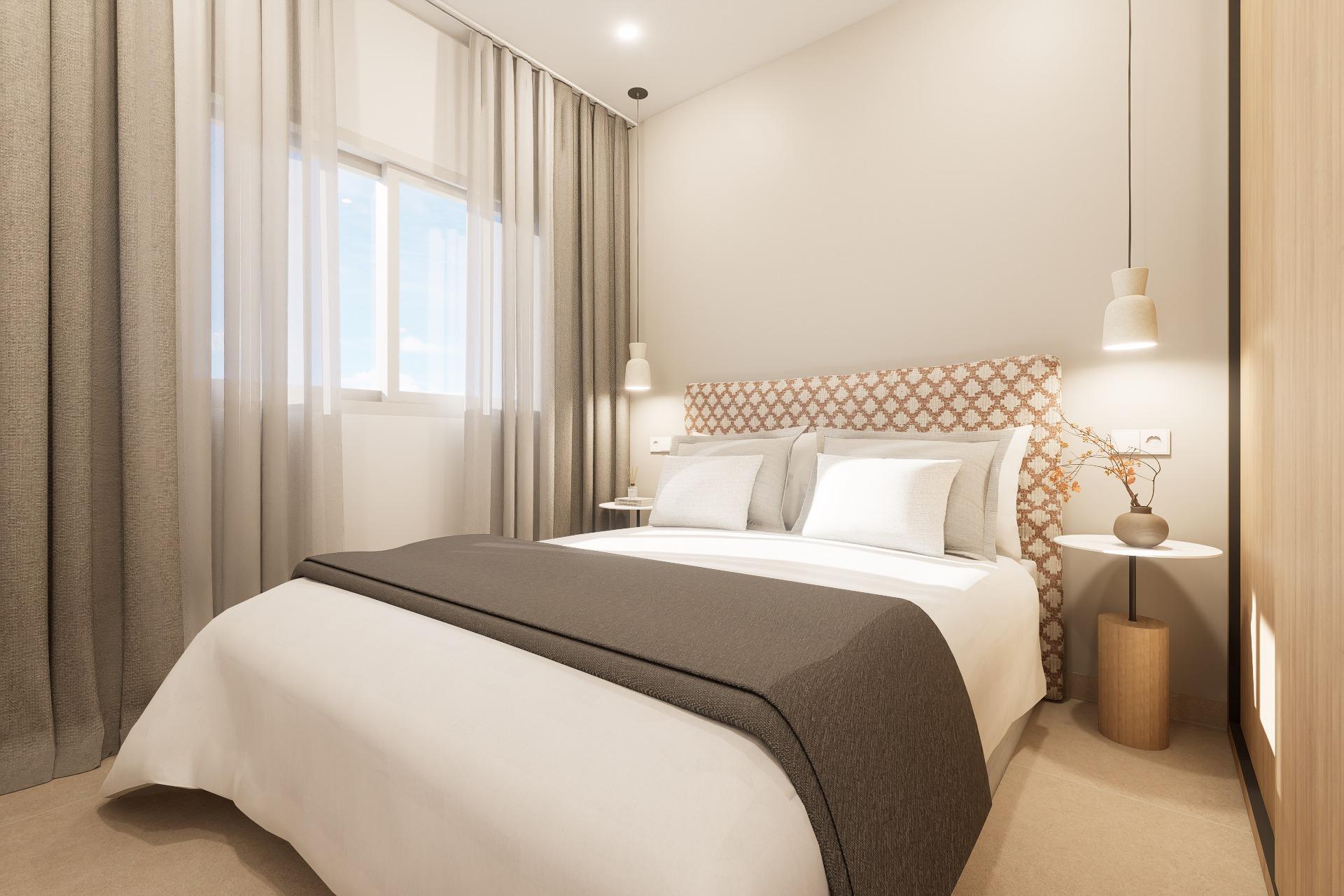 Modern hotel bedroom with a large bed, patterned headboard, and neutral tones; pendant lights above each side table.