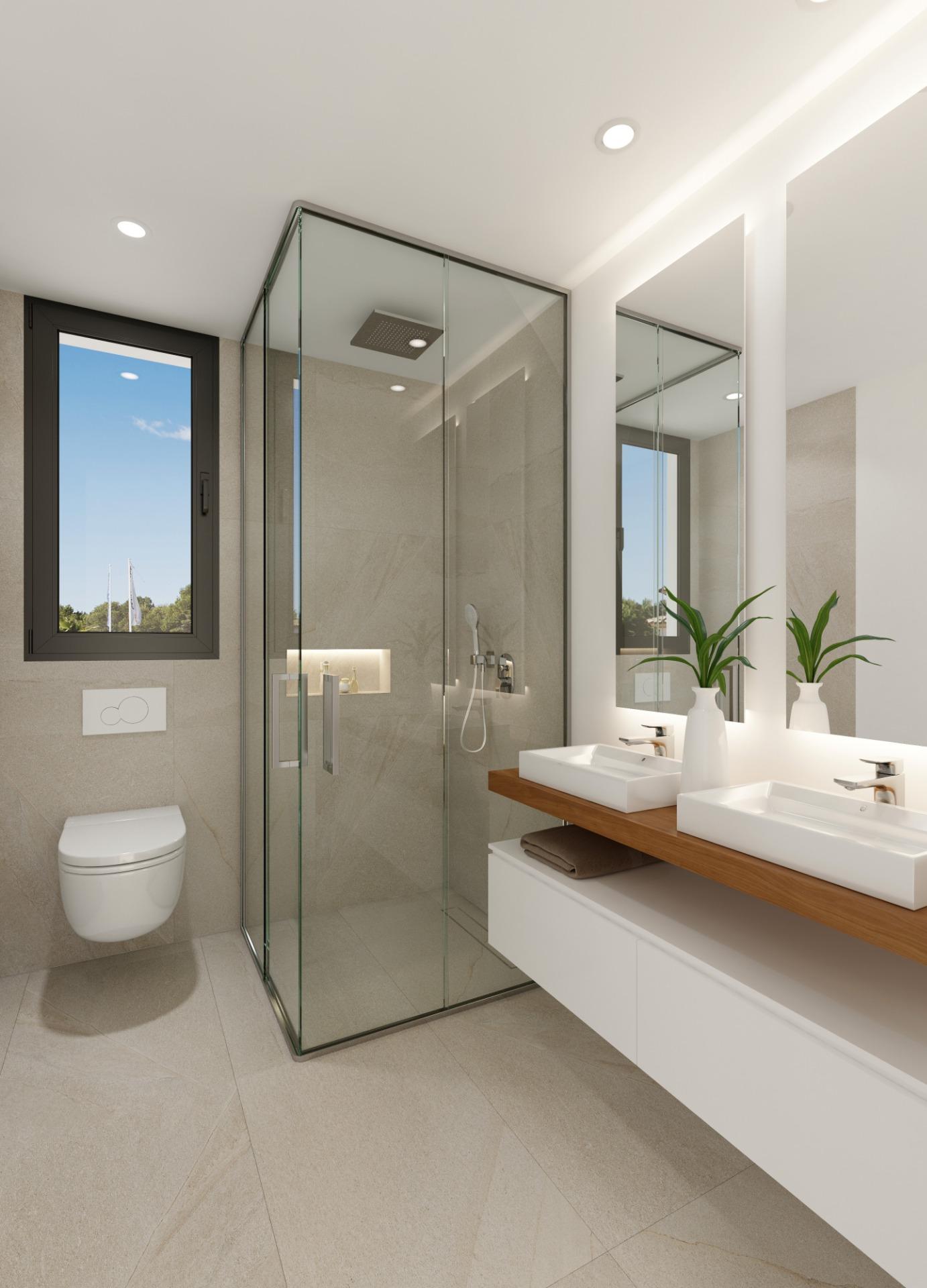 Modern bathroom with a glass-walled shower, double vanity, and potted plants by a large backlit mirror.