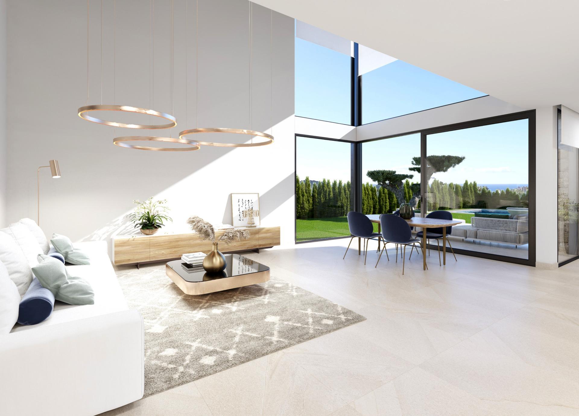 Open-plan living area with large glass walls, circular pendant lights, and a tan rug; view of a garden and outdoor dining area through floor-to-ceiling windows.