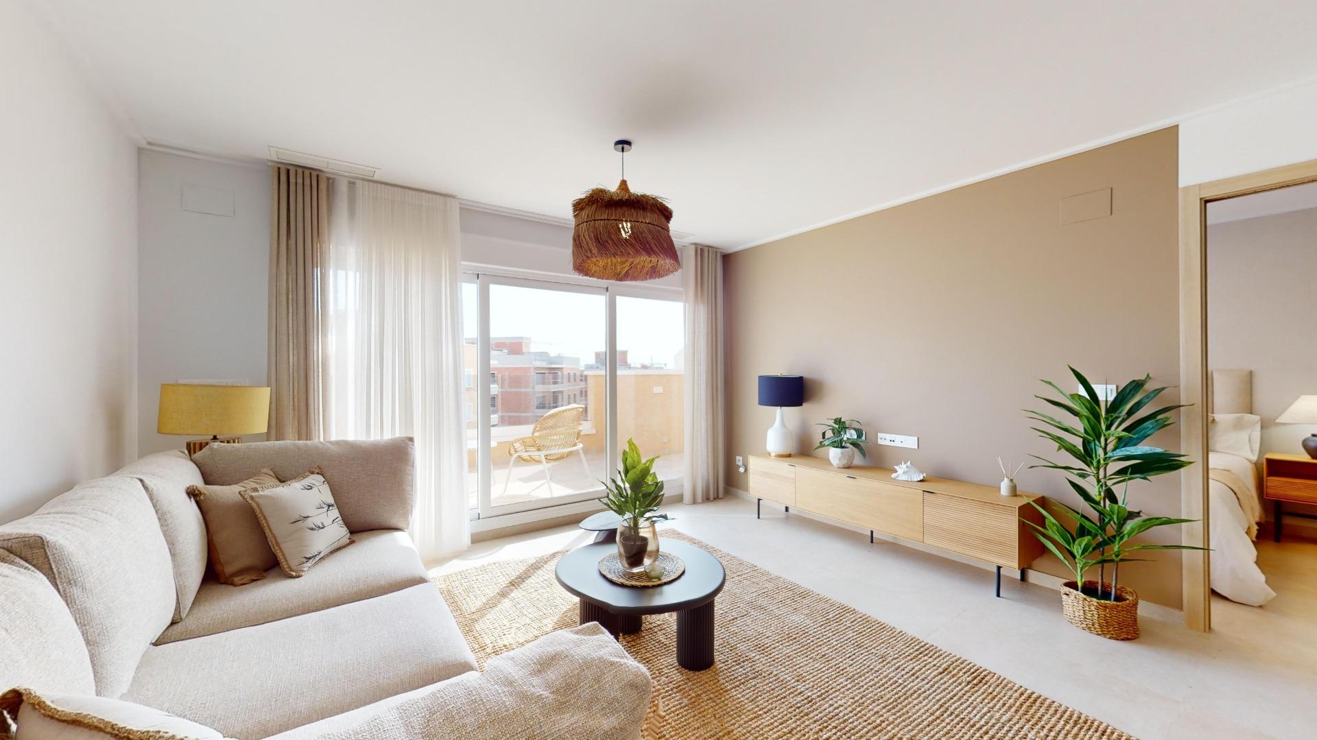 Bright living room with a beige sectional sofa, round black coffee table, woven rug, and a hanging woven pendant light; sliding balcony doors open to a city view.