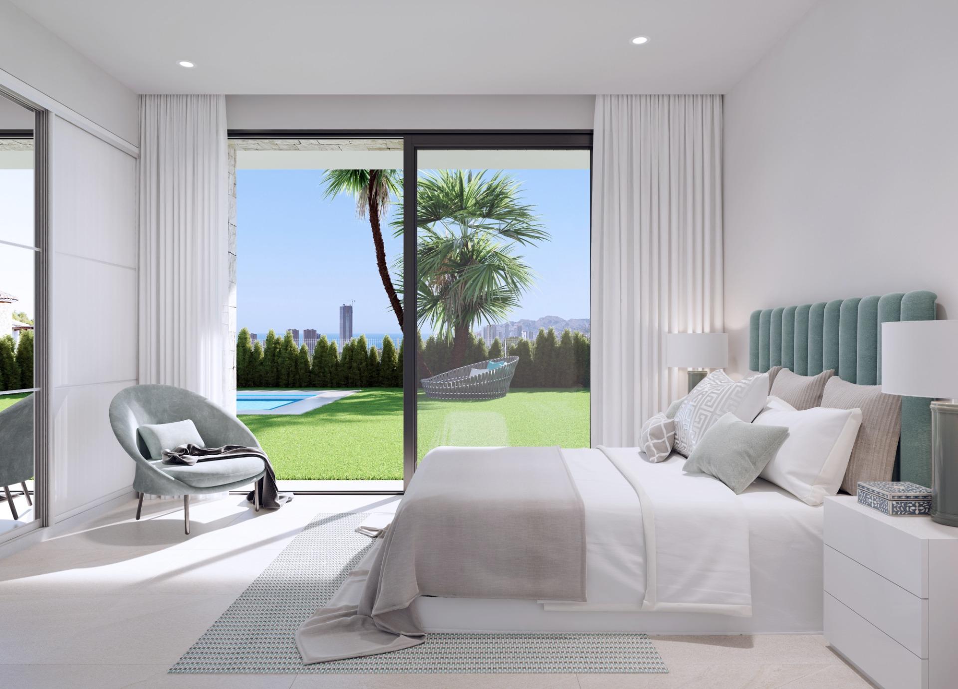 Bright modern bedroom with large glass doors opening to a pool, lawn, and palm trees outside.