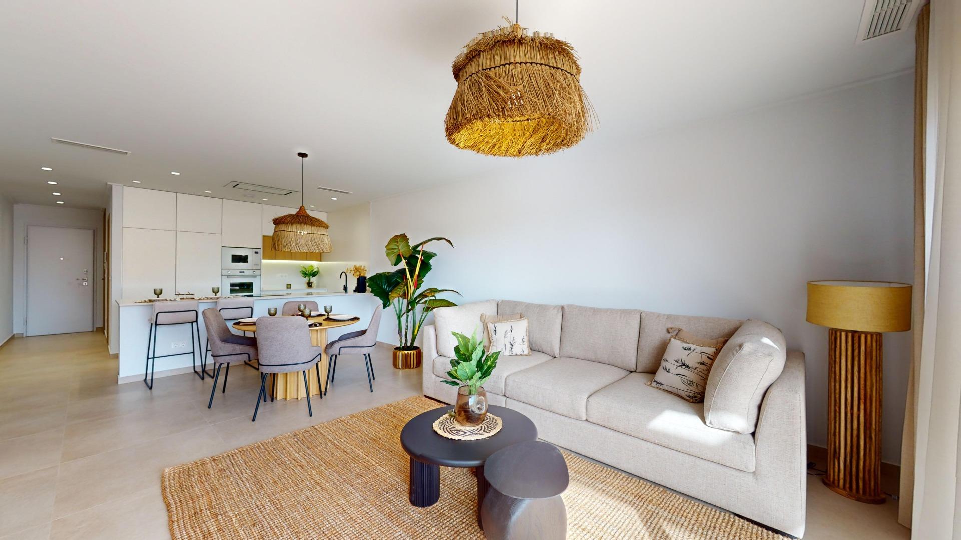 Open-plan living area with a beige sofa, round dining table, and a white kitchen island under large woven pendant lights.