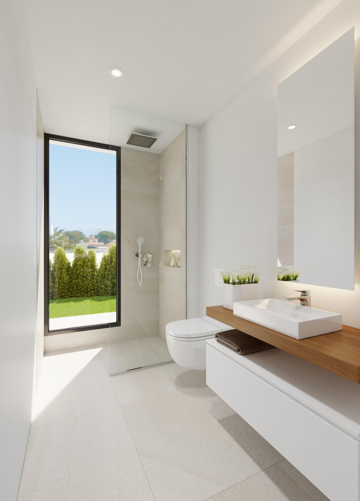 Bright, minimal bathroom with glass shower enclosure, large window, and white fixtures on a wooden countertop mirror wall