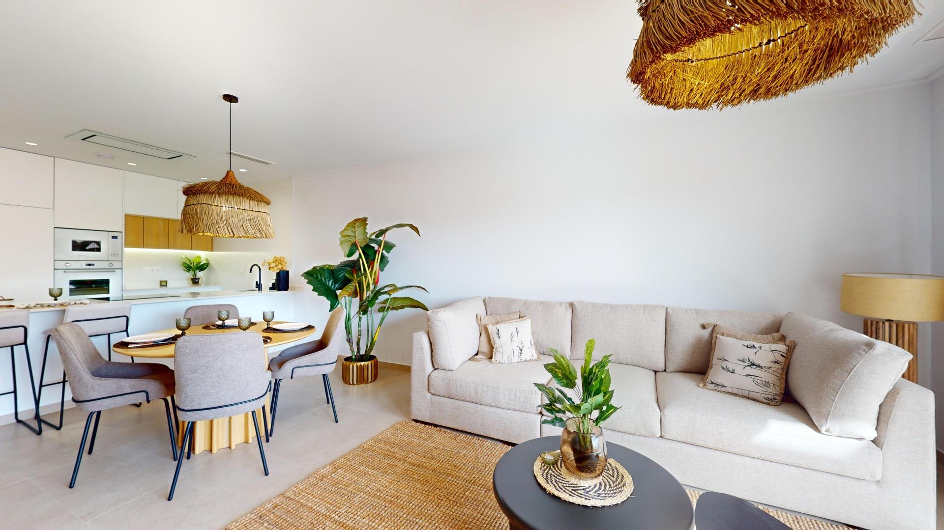 Open‑plan living area with a beige sectional sofa, round coffee tables, dining set, and a white kitchen; two large woven wicker pendant lights hang from the ceiling.