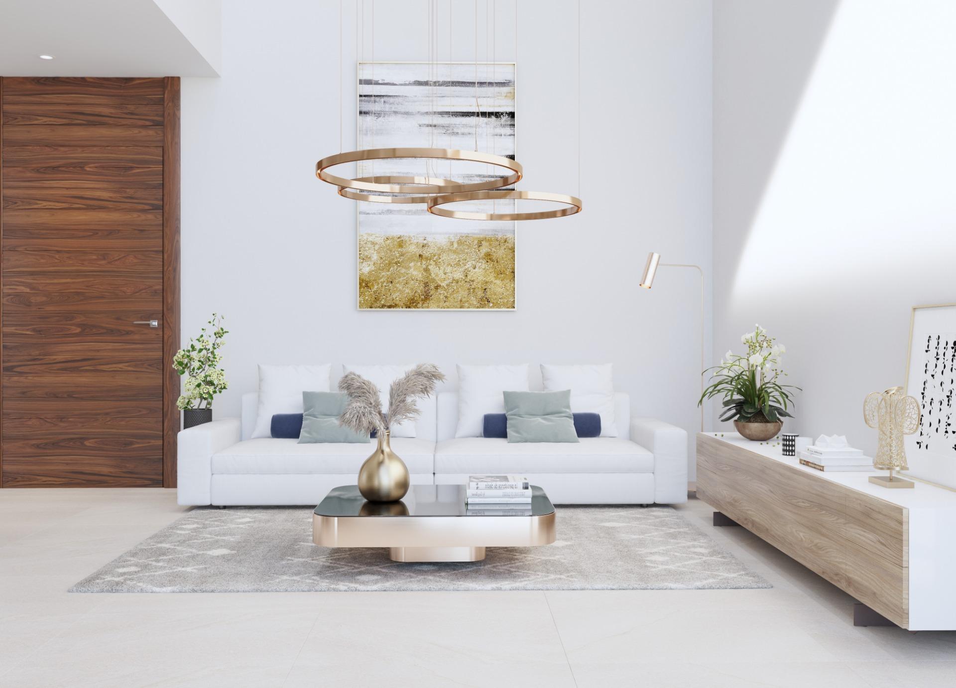 Modern living room with a white sofa, gray rug, and a gold circular chandelier above.